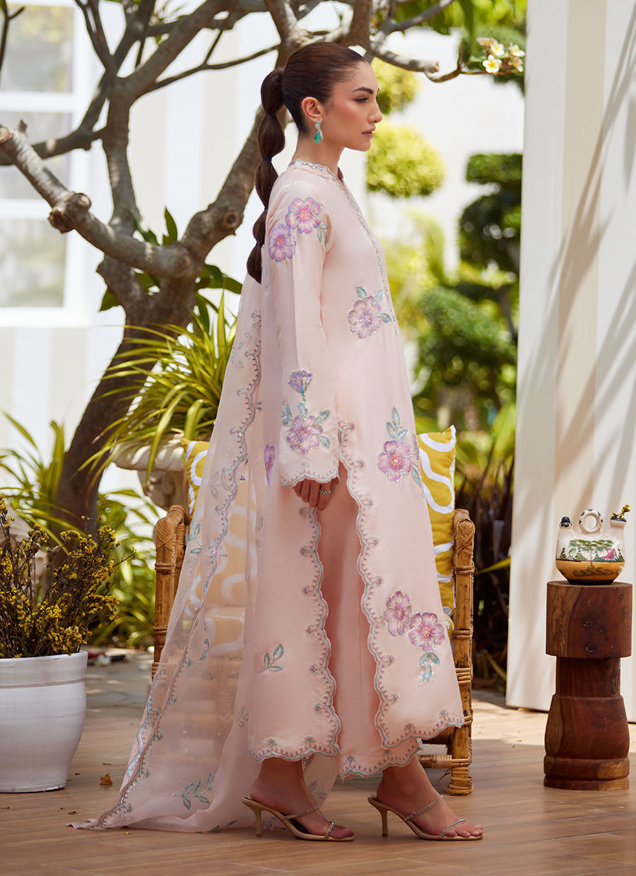 Model wearing blush pink floral embroidered dress from Farah Talib Aziz, ideal Pakistani luxury pret for summer garden parties in the UK.