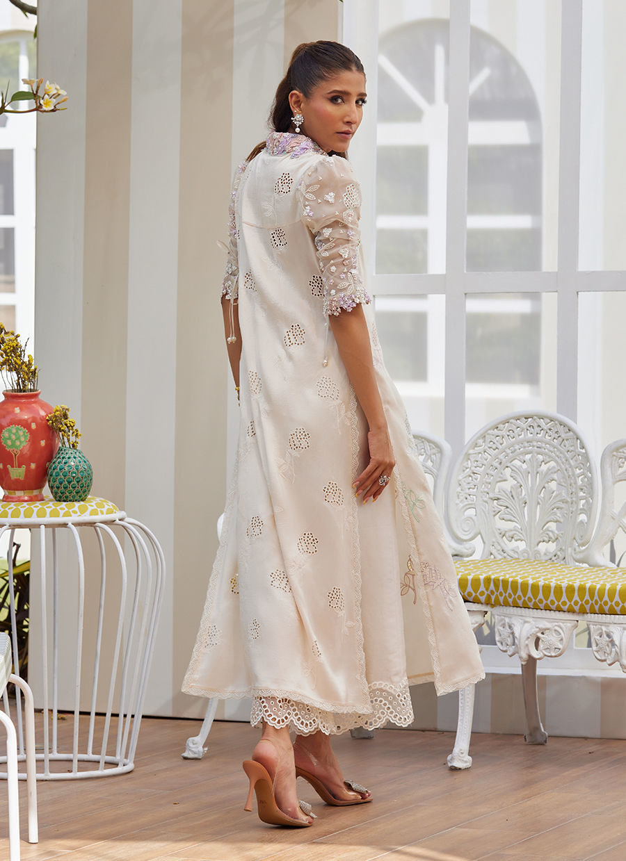 Model wearing ivory embroidered dress with pastel floral details from Farah Talib Aziz, perfect for Pakistani luxury pret in the UK.