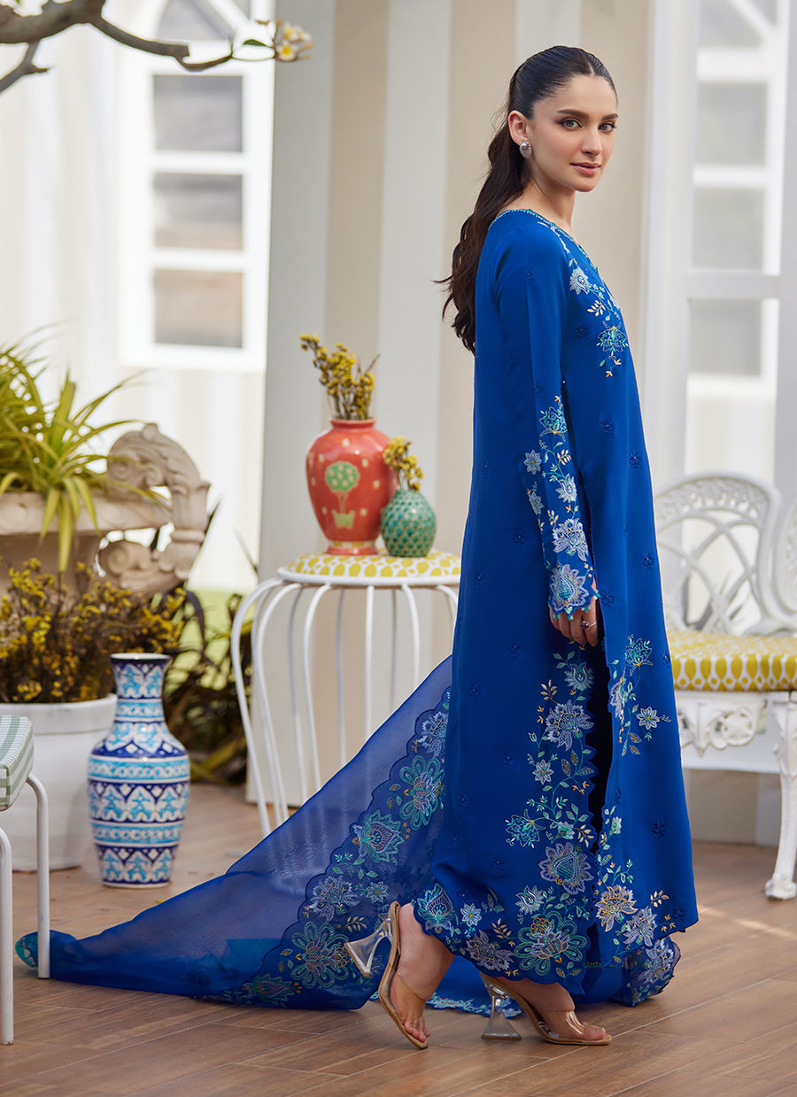 Model wearing cobalt blue embroidered dress with floral detailing from Farah Talib Aziz, ideal for Pakistani luxury pret online in UK.