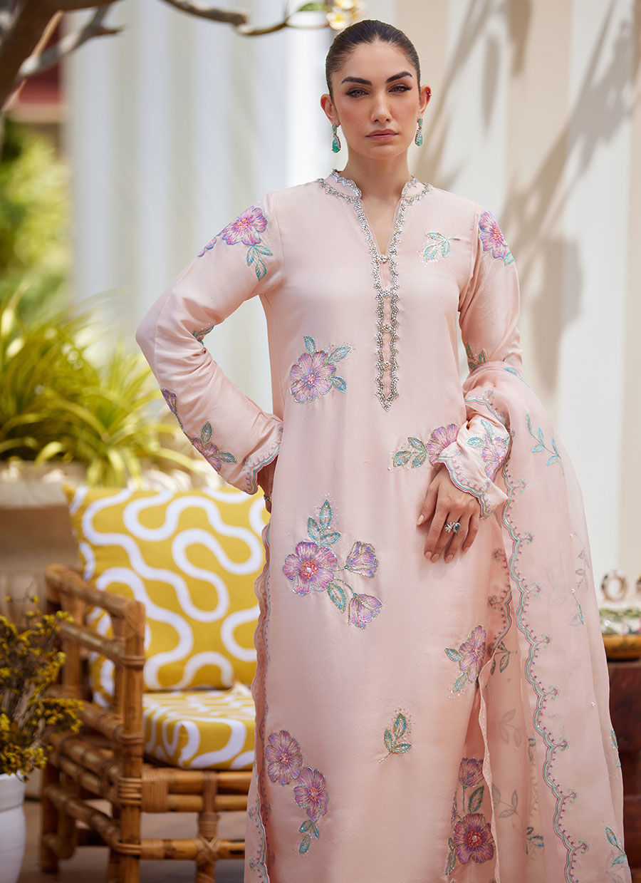 Model wearing blush pink floral embroidered dress from Farah Talib Aziz, ideal Pakistani luxury pret for summer garden parties in the UK.