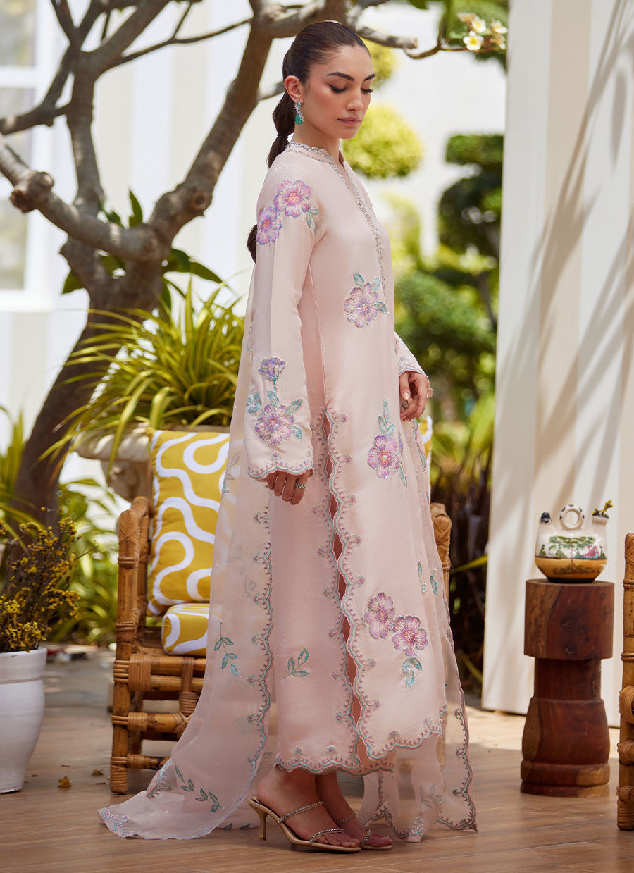 Model wearing blush pink floral embroidered dress from Farah Talib Aziz, ideal Pakistani luxury pret for summer garden parties in the UK.