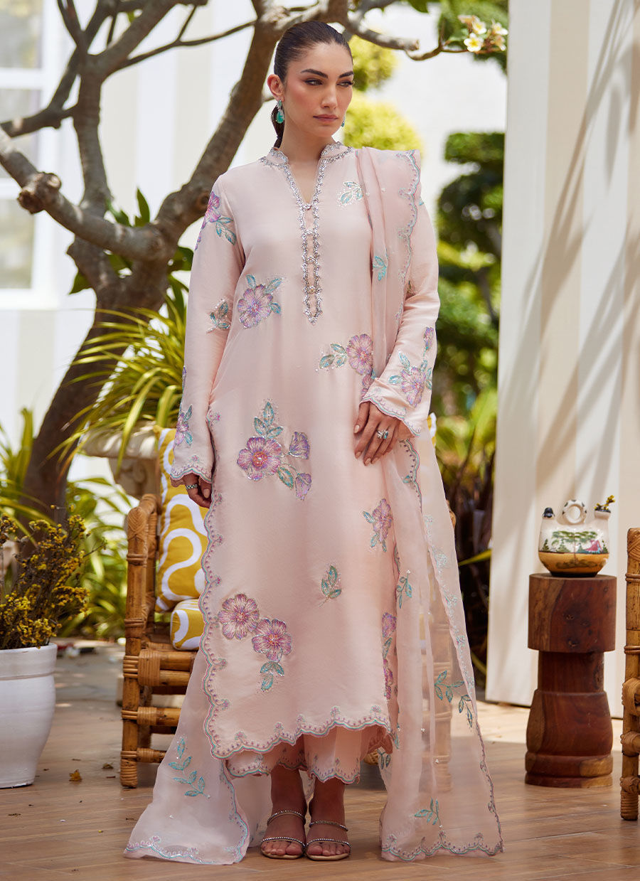Model wearing blush pink floral embroidered dress from Farah Talib Aziz, ideal Pakistani luxury pret for summer garden parties in the UK.