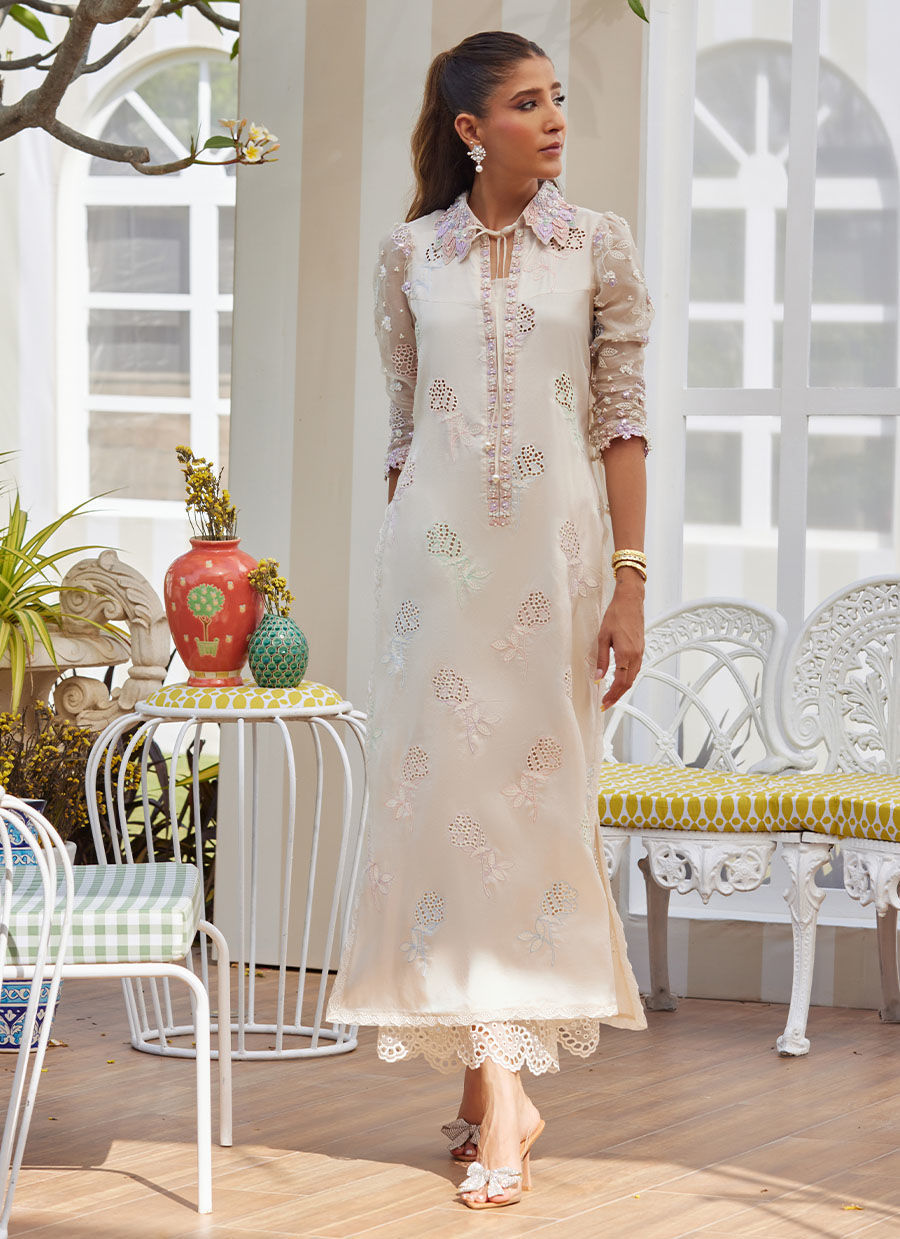 Model wearing ivory embroidered dress with pastel floral details from Farah Talib Aziz, perfect for Pakistani luxury pret in the UK.