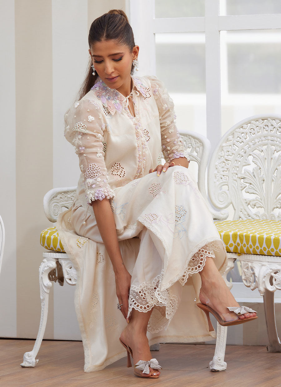 Model wearing ivory embroidered dress with pastel floral details from Farah Talib Aziz, perfect for Pakistani luxury pret in the UK.