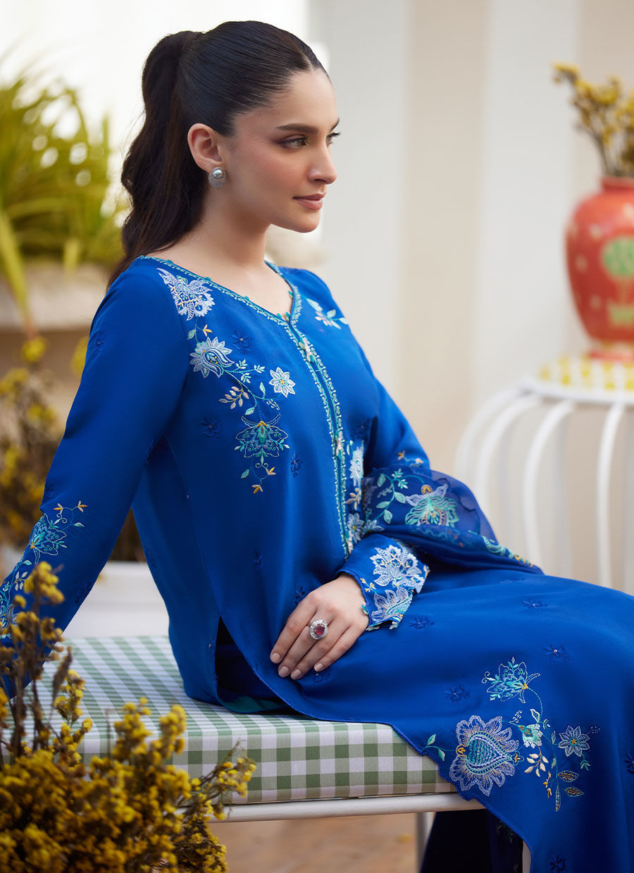 Model wearing cobalt blue embroidered dress with floral detailing from Farah Talib Aziz, ideal for Pakistani luxury pret online in UK.