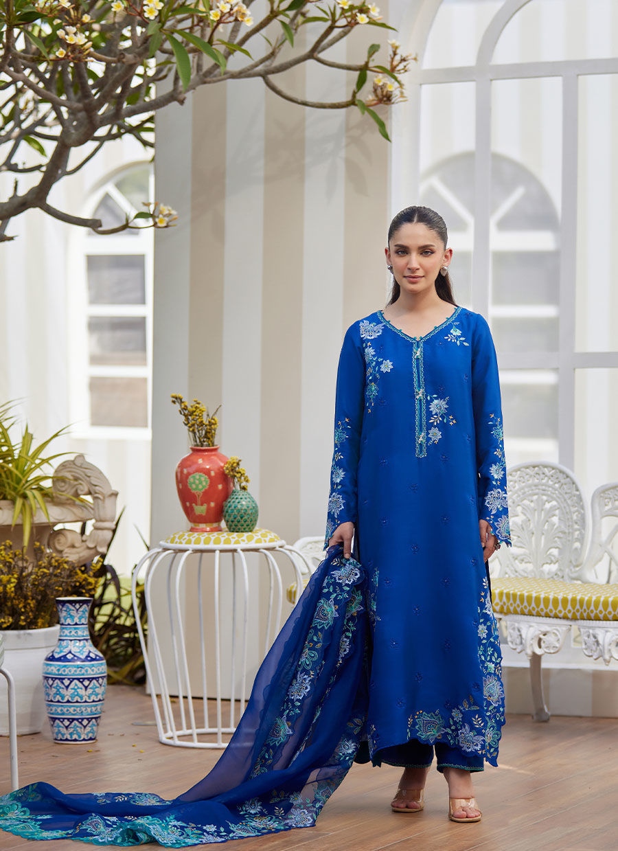 Model wearing cobalt blue embroidered dress with floral detailing from Farah Talib Aziz, ideal for Pakistani luxury pret online in UK.