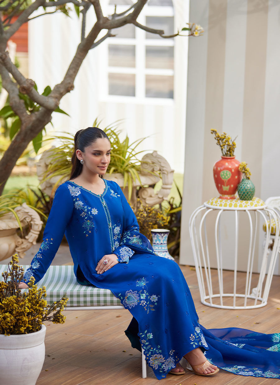Model wearing cobalt blue embroidered dress with floral detailing from Farah Talib Aziz, ideal for Pakistani luxury pret online in UK.