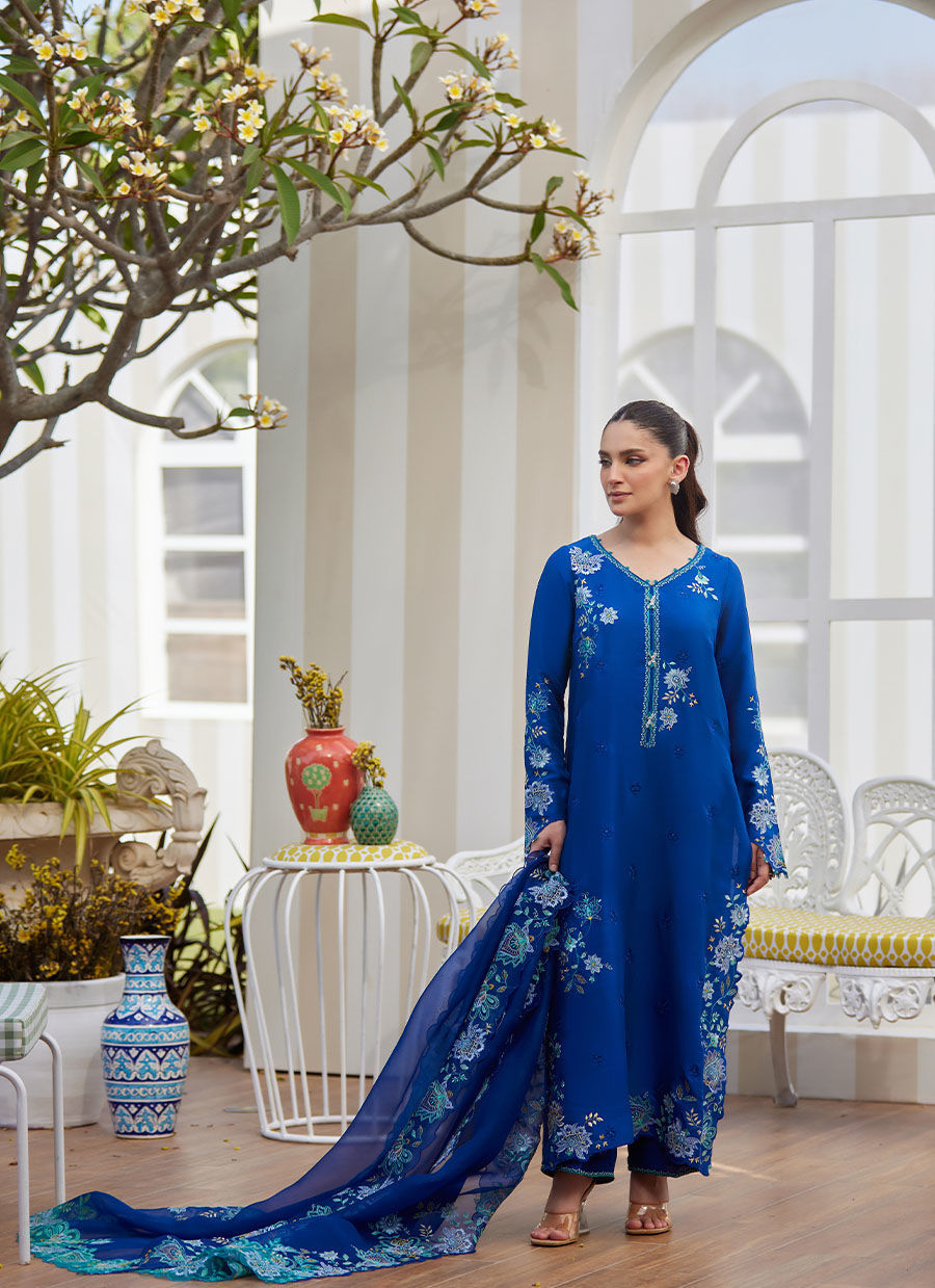 Model wearing cobalt blue embroidered dress with floral detailing from Farah Talib Aziz, ideal for Pakistani luxury pret online in UK.