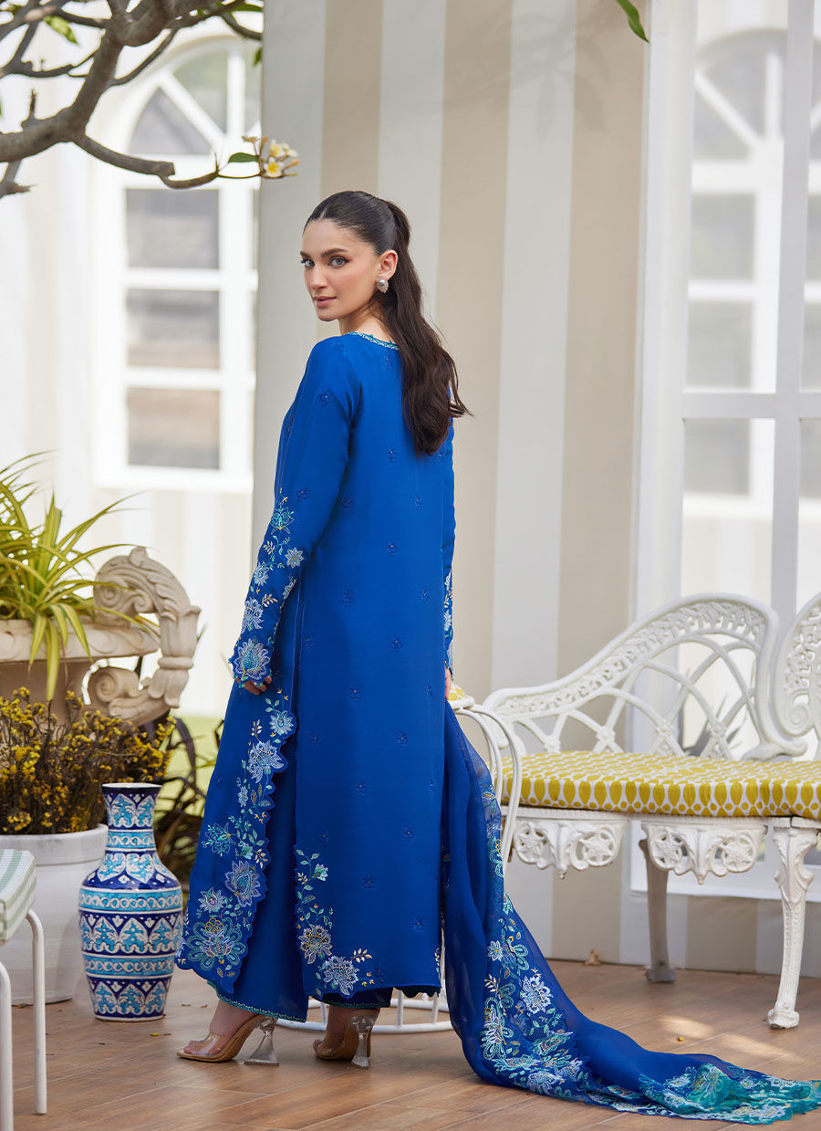 Model wearing cobalt blue embroidered dress with floral detailing from Farah Talib Aziz, ideal for Pakistani luxury pret online in UK.