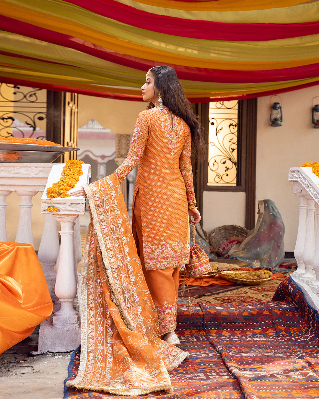 model wearing orange dress by Faiza Saqlain, Pakistani luxury pret ideal for online shopping in the UK