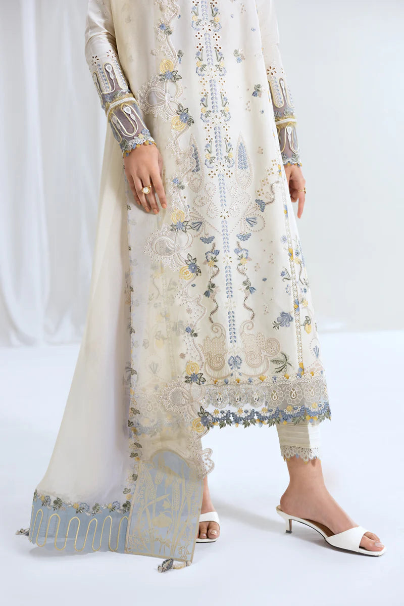 Model wearing ivory Qalamkar SB-09 Adeena embroidered outfit with sky blue accents, perfect for Eid and Pakistani luxury pret online in UK.