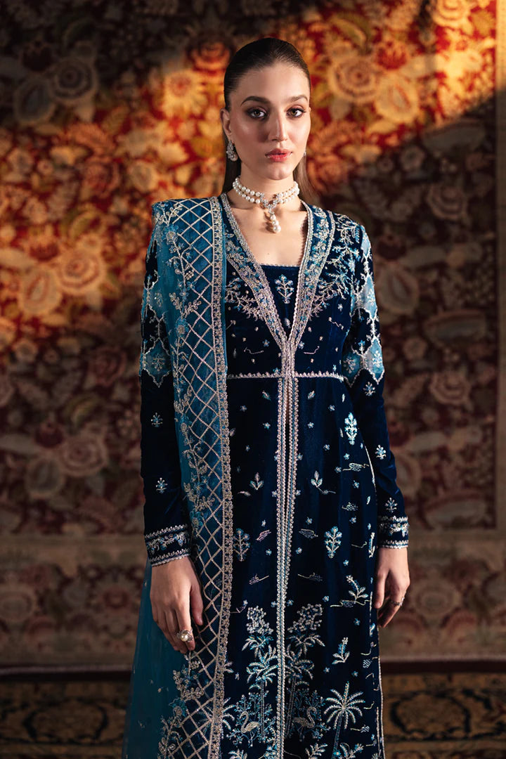 Model wearing Qalamkar Velvet Edit '24 BK-07 LIYANA, a deep blue velvet dress adorned with intricate embroidery, ideal for weddings. Available as Pakistani clothes online in the UK.