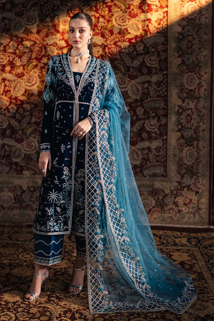 Model wearing Qalamkar Velvet Edit '24 BK-07 LIYANA, a deep blue velvet dress adorned with intricate embroidery, ideal for weddings. Available as Pakistani clothes online in the UK.