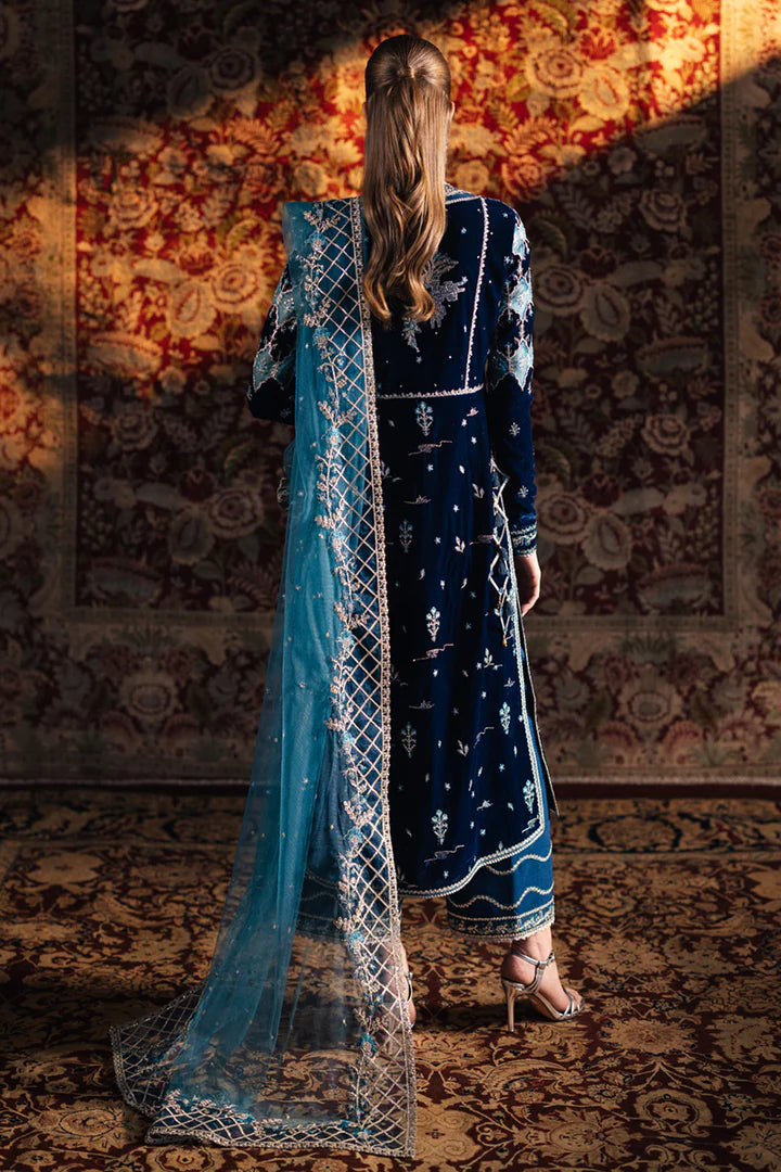 Model wearing Qalamkar Velvet Edit '24 BK-07 LIYANA, a deep blue velvet dress adorned with intricate embroidery, ideal for weddings. Available as Pakistani clothes online in the UK.