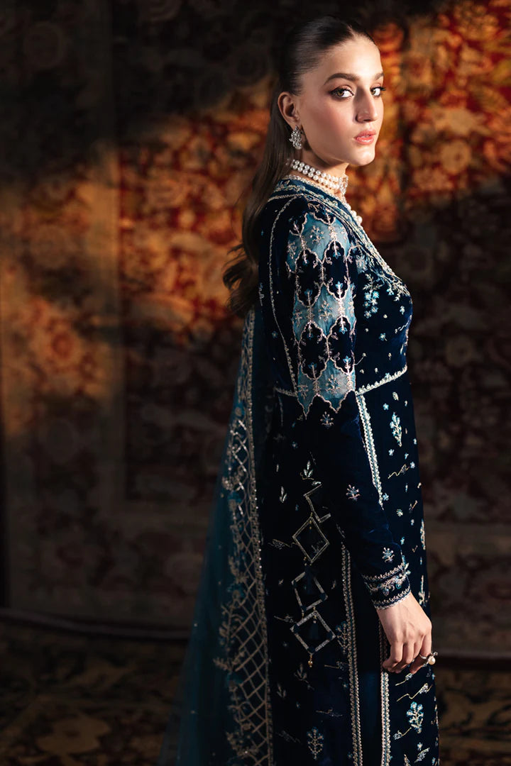 Model wearing Qalamkar Velvet Edit '24 BK-07 LIYANA, a deep blue velvet dress adorned with intricate embroidery, ideal for weddings. Available as Pakistani clothes online in the UK.