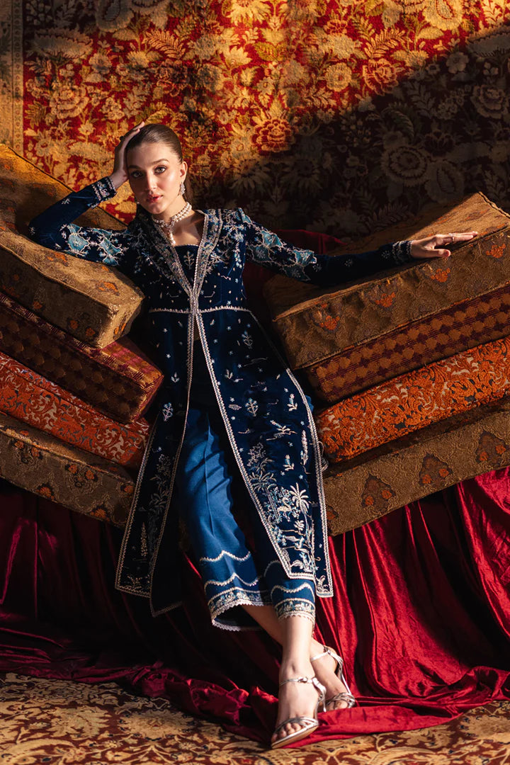 Model wearing Qalamkar Velvet Edit '24 BK-07 LIYANA, a deep blue velvet dress adorned with intricate embroidery, ideal for weddings. Available as Pakistani clothes online in the UK.