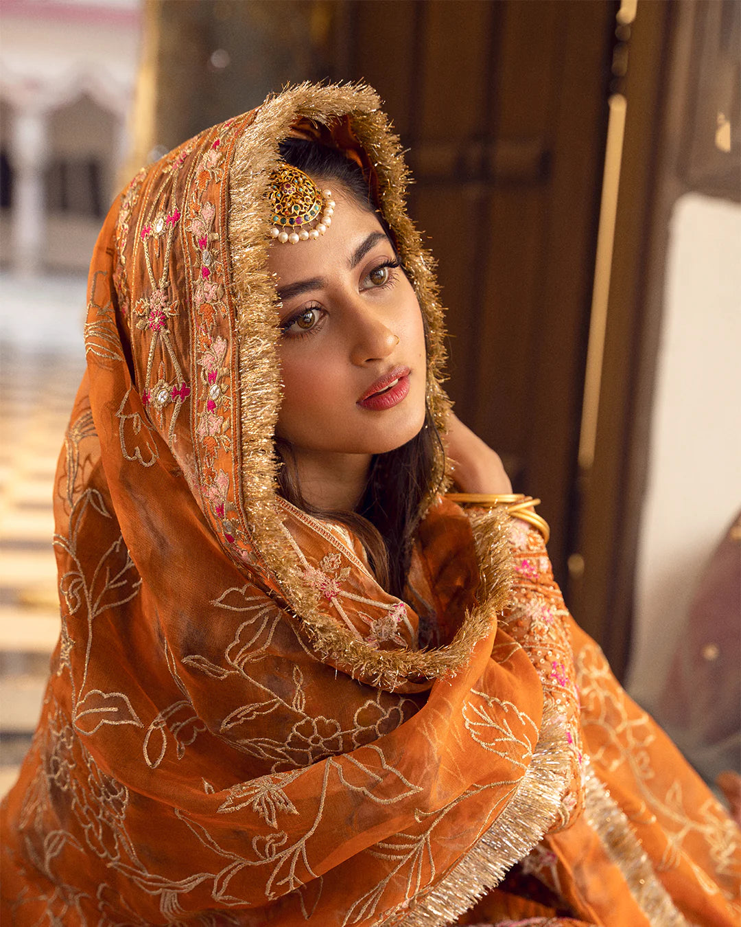 model wearing orange dress by Faiza Saqlain, Pakistani luxury pret ideal for online shopping in the UK