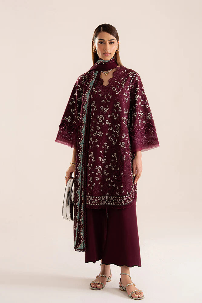 Model wearing Omya by Suffuse in deep maroon with intricate embroidery – sophisticated Pakistani luxury pret outfit in UK.