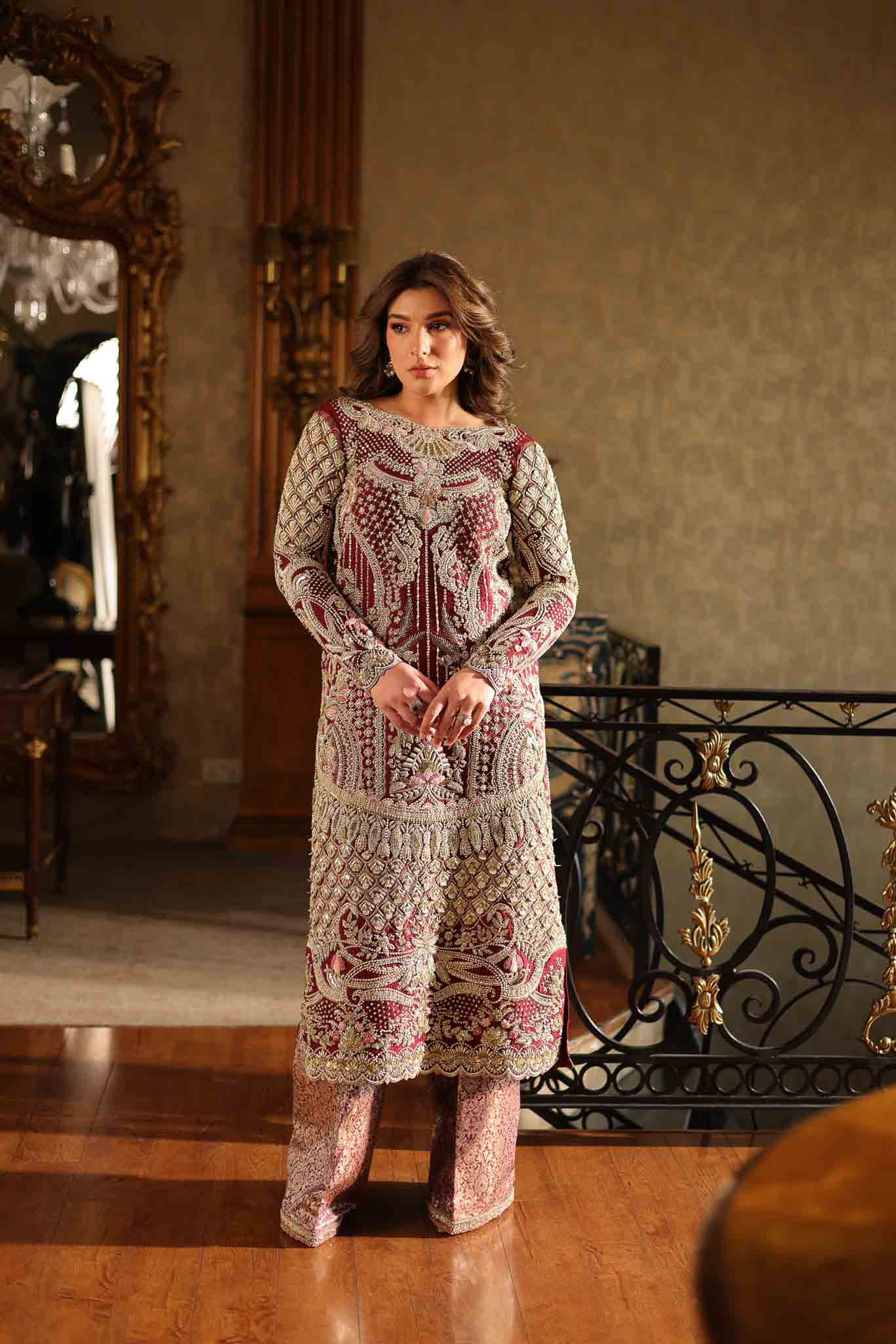 Model wearing deep maroon and gold hand-embellished long shirt with matching trousers from Mysie By Tahira Ruby, Pakistani Luxury pret UK.