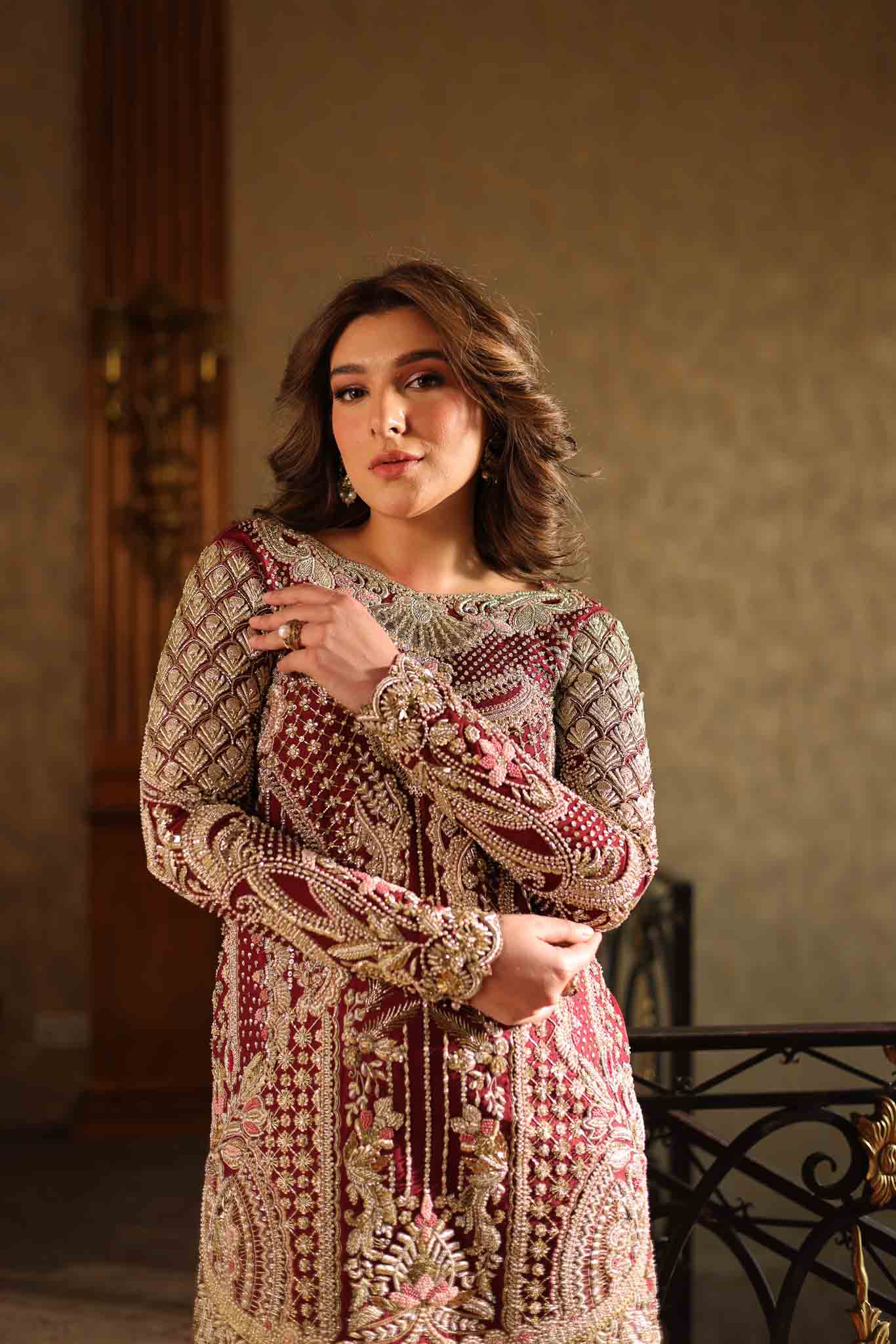 Model wearing deep maroon and gold hand-embellished long shirt with matching trousers from Mysie By Tahira Ruby, Pakistani Luxury pret UK.