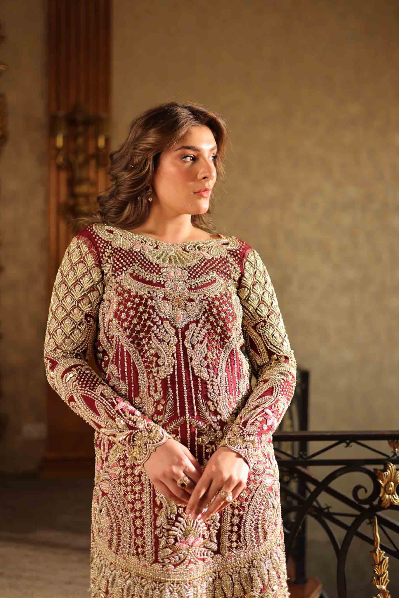 Model wearing deep maroon and gold hand-embellished long shirt with matching trousers from Mysie By Tahira Ruby, Pakistani Luxury pret UK.