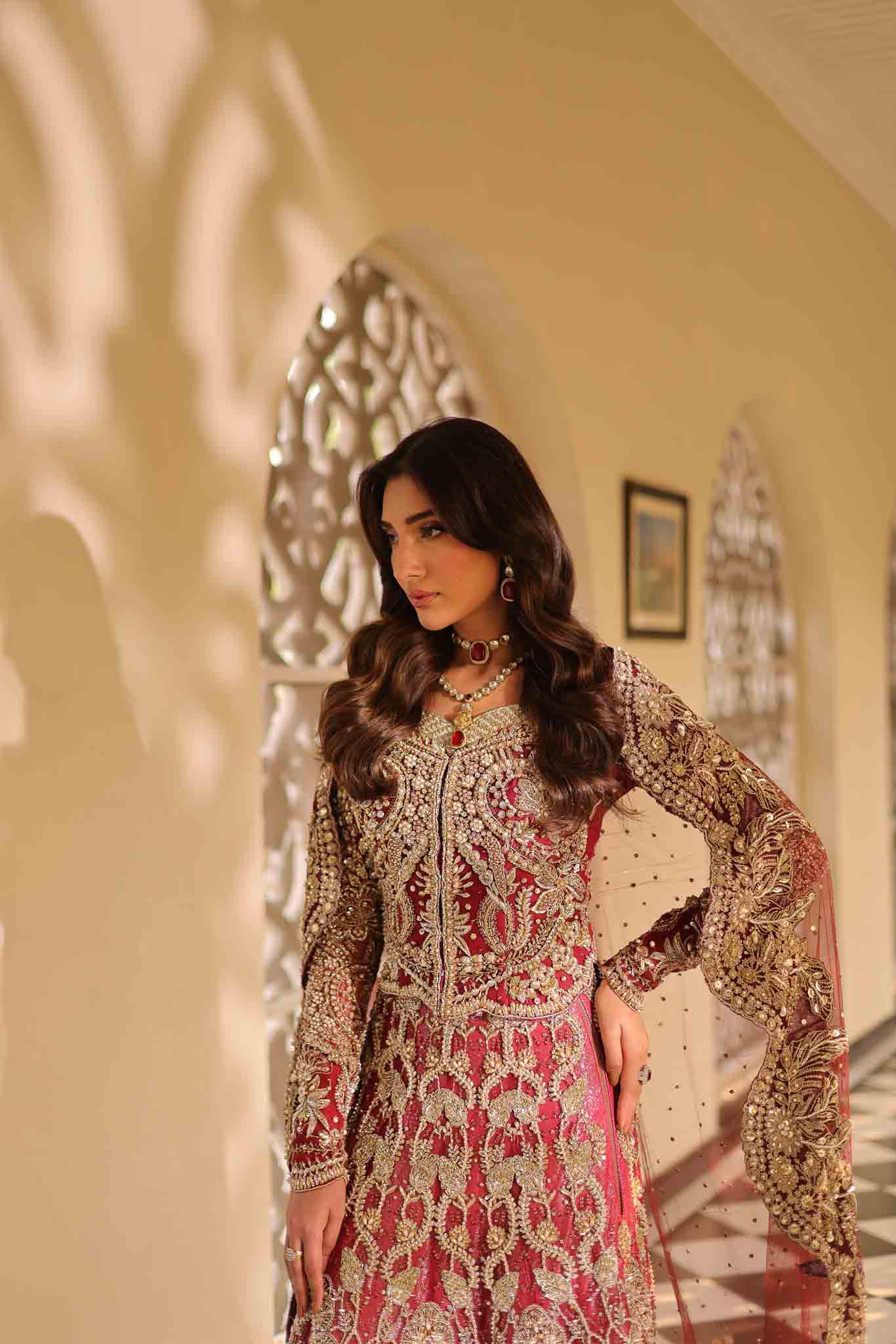 Model wearing deep red and gold bridal gown AURAA from Mysie by Tahira, Pakistani luxury pret available online in UK for weddings.