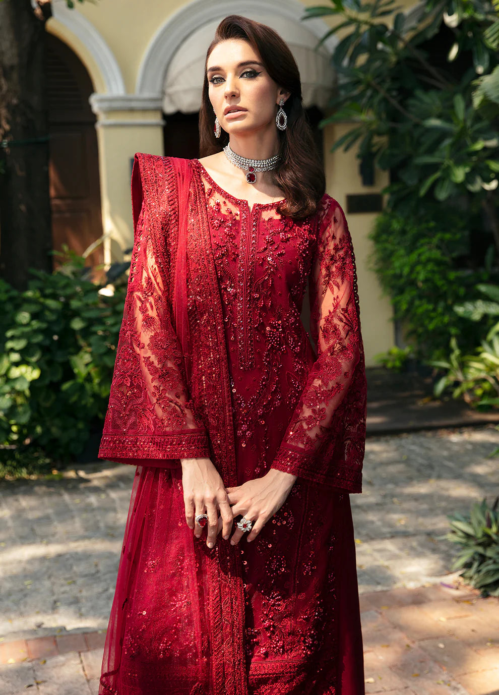 Model wearing Gulaal CHARLOTTE red embellished dress, UK Pakistani luxury attire.