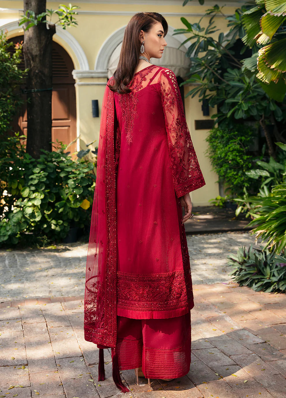 Model wearing Gulaal CHARLOTTE red embellished dress, UK Pakistani luxury attire.