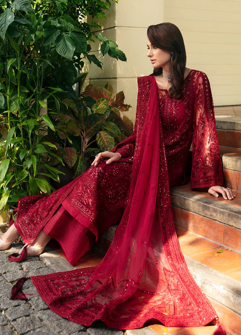 Model wearing Gulaal CHARLOTTE red embellished dress, UK Pakistani luxury attire.