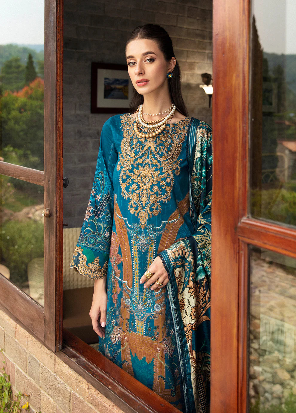 Model in Gulaal ESILA dress, teal with gold embroidery.