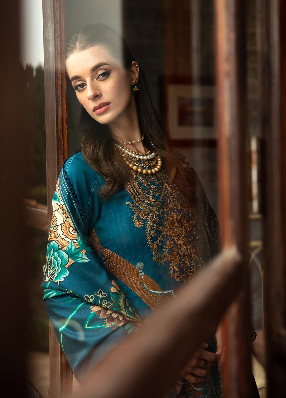 Model in Gulaal ESILA dress, teal with gold embroidery.