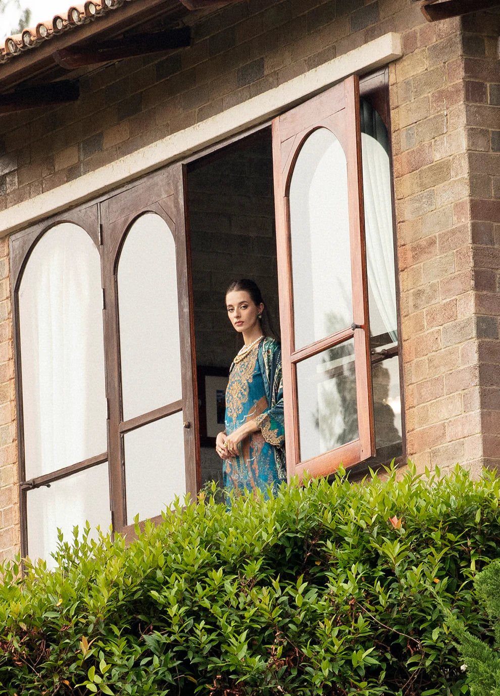 Model in Gulaal ESILA dress, teal with gold embroidery.