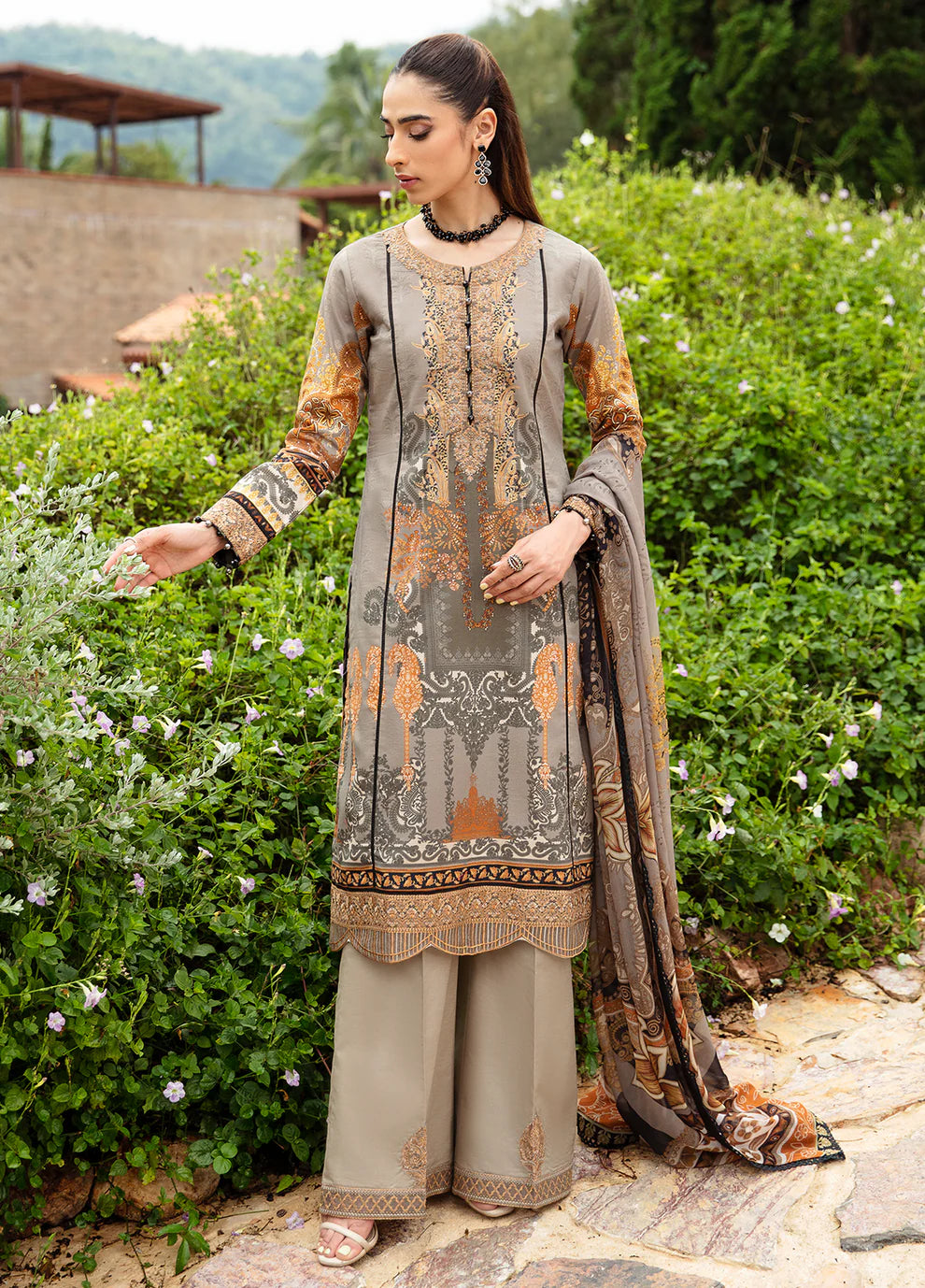 Model in Gulaal's AMIRAT dress, earth tones with luxe patterns