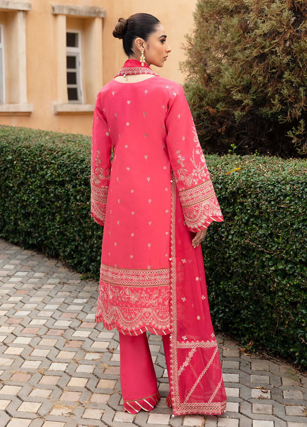 Model in Gulaal's ALESSIA dress, pink luxury lawn with exquisite detailing, a UK Pakistani fashion staple.