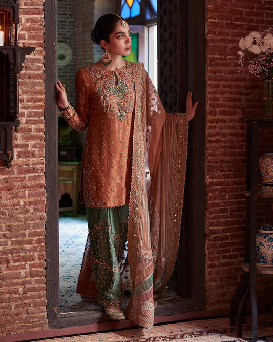 model wearing rust and green embroidered dress by Faiza Saqlain, Pakistani luxury pret available online in UK
