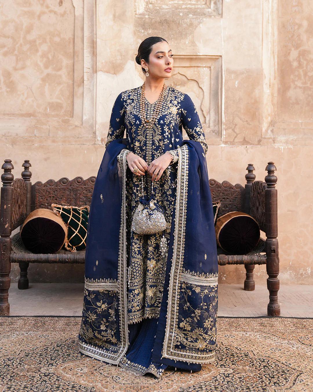 Model wearing navy blue Faiza Saqlain Ayska outfit with intricate gold embroidery, ideal for Pakistani luxury pret and festive wear in UK.