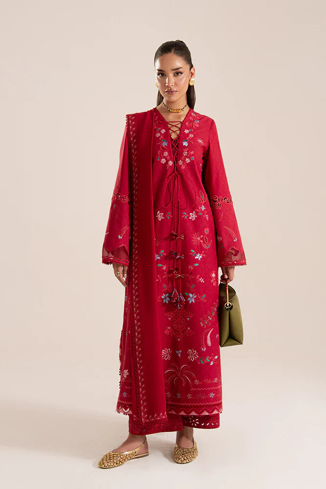 Model wearing Nivvi by Suffuse in deep red, a printed and embroidered Pakistani luxury pret outfit – shop Pakistani clothes online in UK.