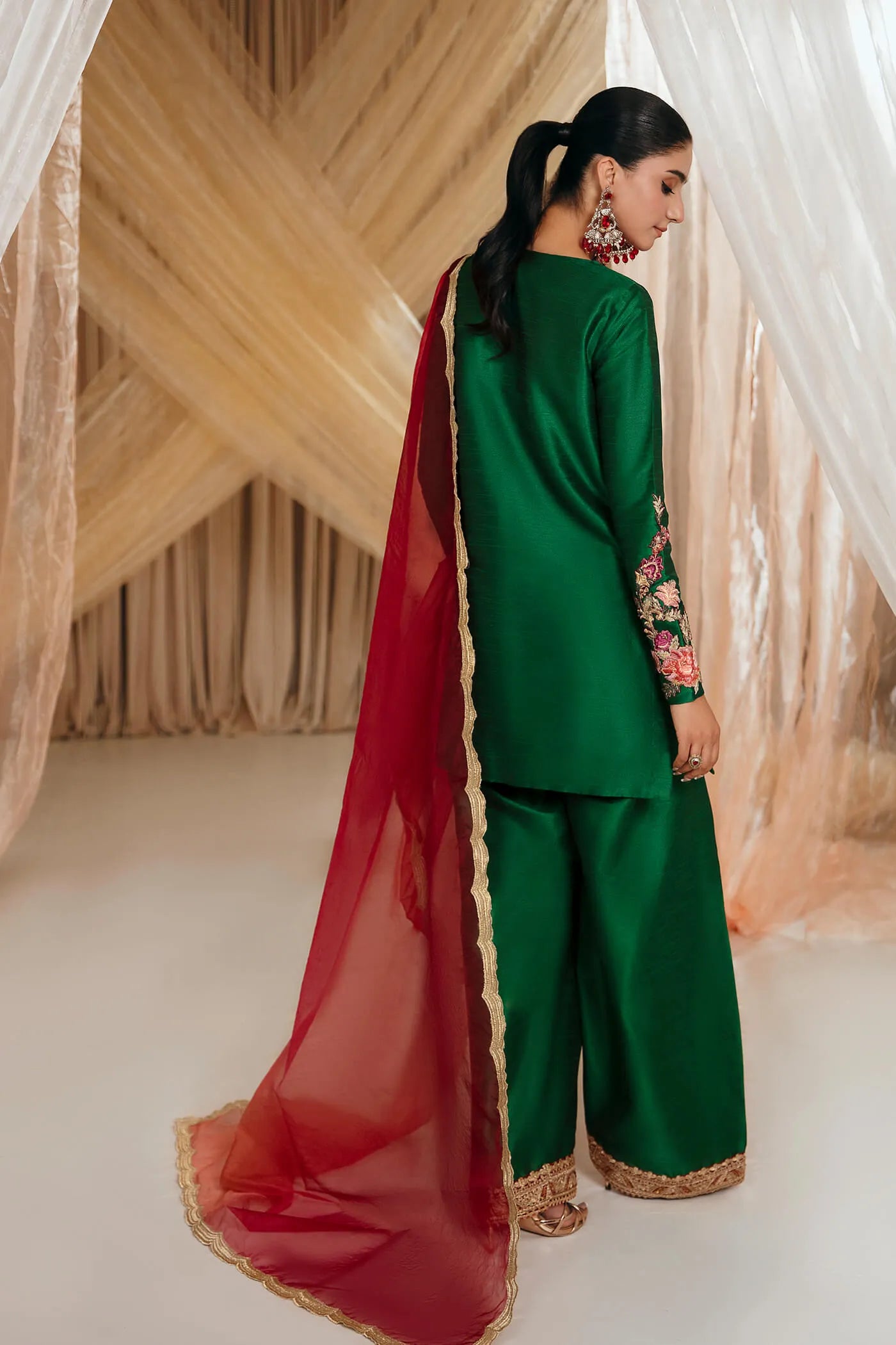 Model wearing Faiza Saqlain's Emerald Garden dress from the Musferah Saad Mystere Eid Collection '24. A stunning green Pakistani Eid dress adorned with rich embroidery, perfect for those seeking Pakistani designer clothes in the UK.