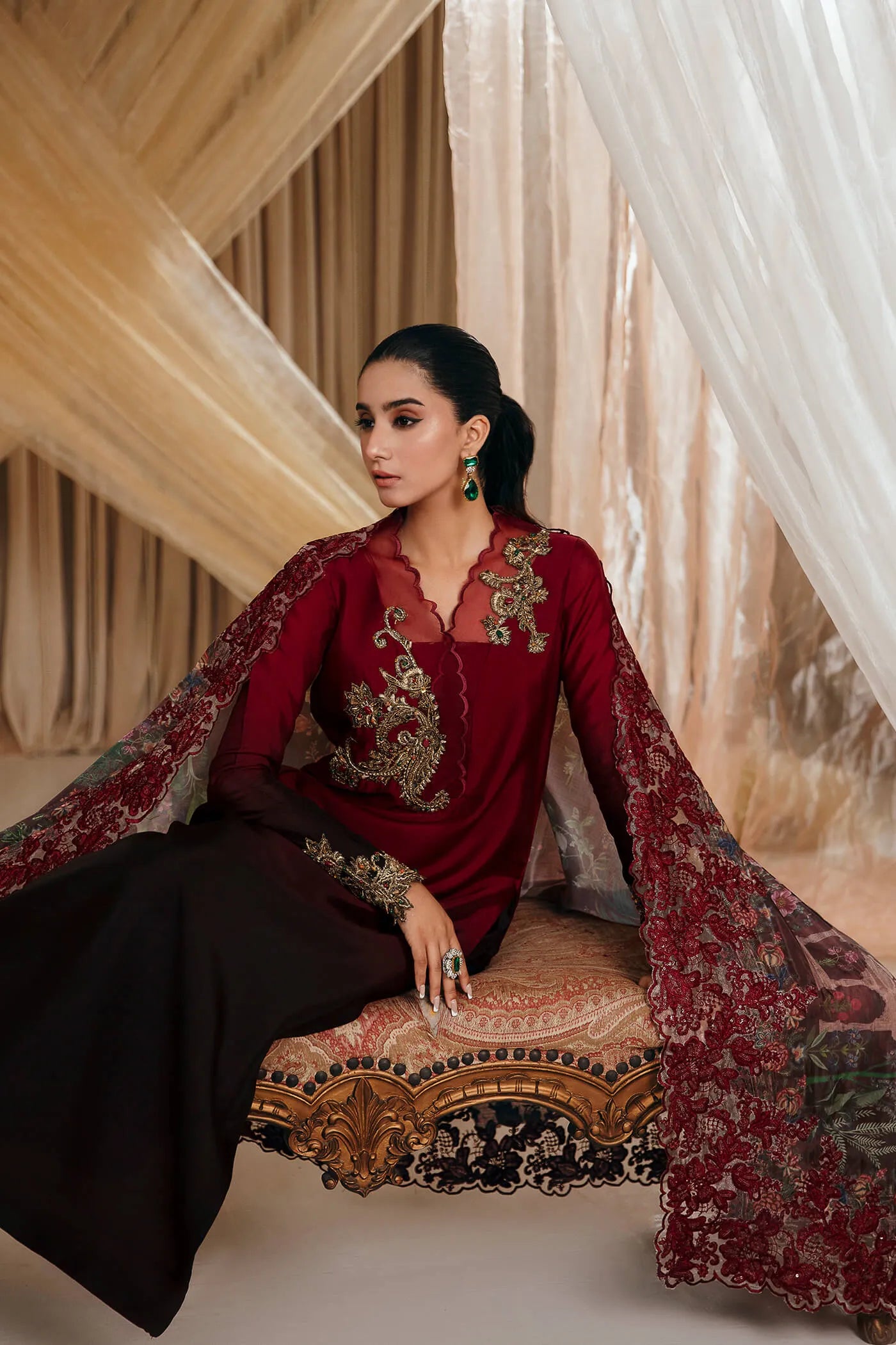 Model wearing Faiza Saqlain's Crimson Rose dress from the Musferah Saad Mystere Eid Collection '24. A striking maroon Pakistani Eid dress with gold embroidery and a beautifully detailed dupatta, ideal for Pakistani designer clothes shoppers in the UK.