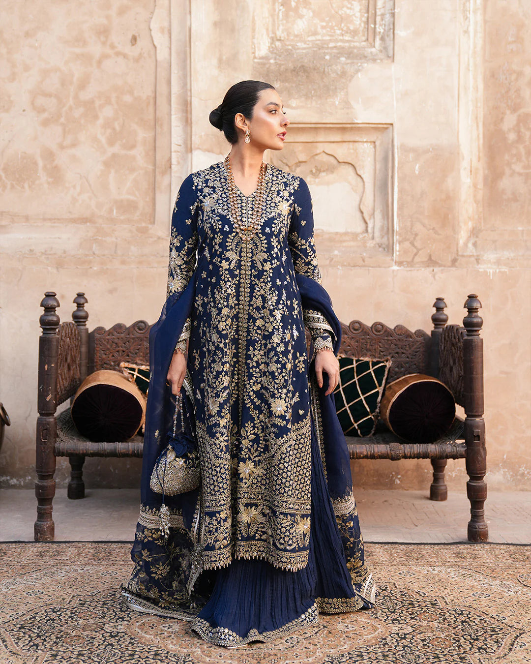Model wearing navy blue Faiza Saqlain Ayska outfit with intricate gold embroidery, ideal for Pakistani luxury pret and festive wear in UK.