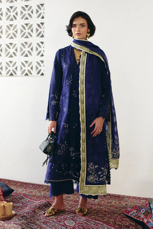 Model in a Suffuse Casual Pret '24 outfit featuring an indigo blue cotton jacquard shirt with cutwork details, paired with matching pants and a dual-color organza dupatta.