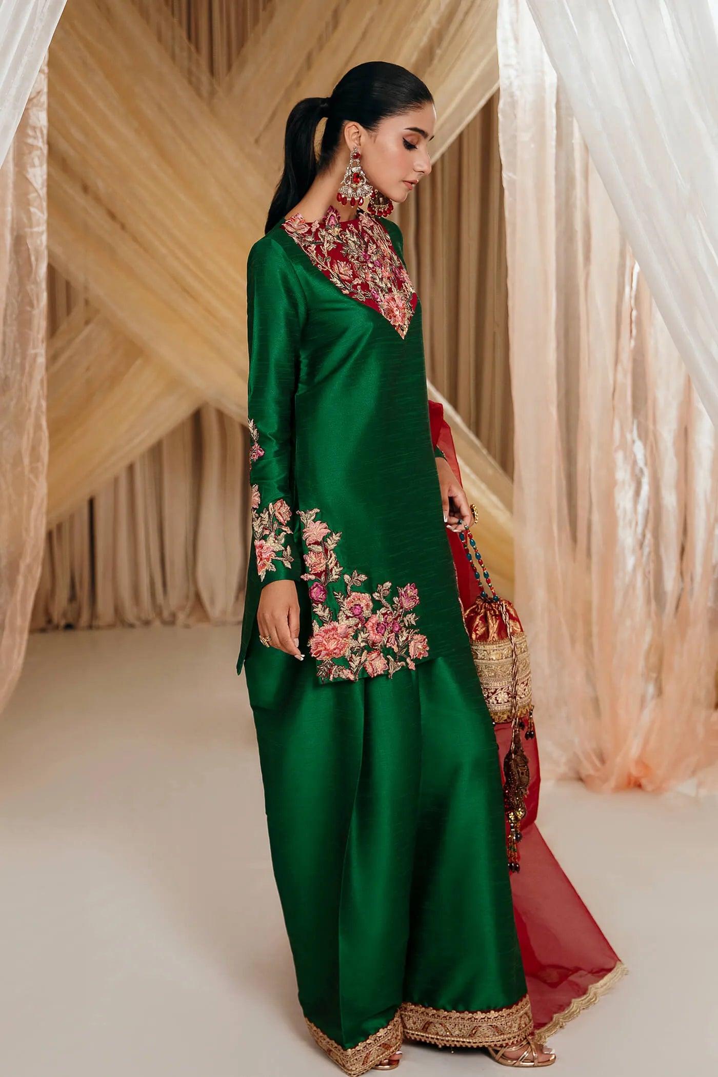 Model wearing Faiza Saqlain's Emerald Garden dress from the Musferah Saad Mystere Eid Collection '24. A stunning green Pakistani Eid dress adorned with rich embroidery, perfect for those seeking Pakistani designer clothes in the UK.