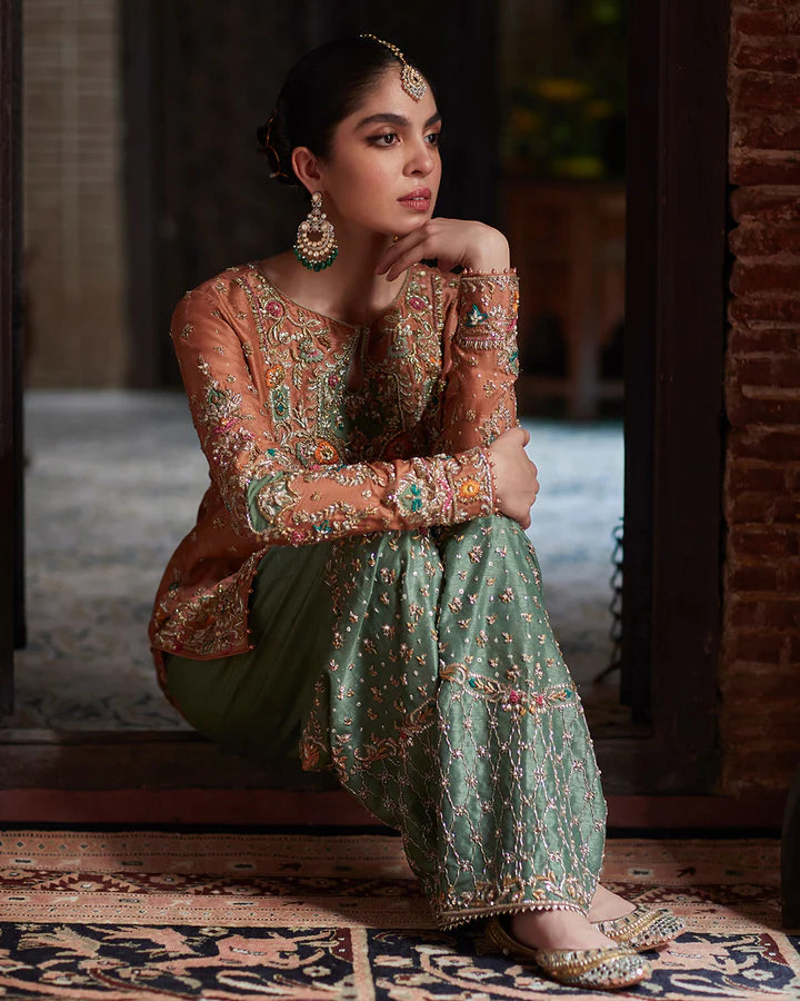 model wearing rust and green embroidered dress by Faiza Saqlain, Pakistani luxury pret available online in UK