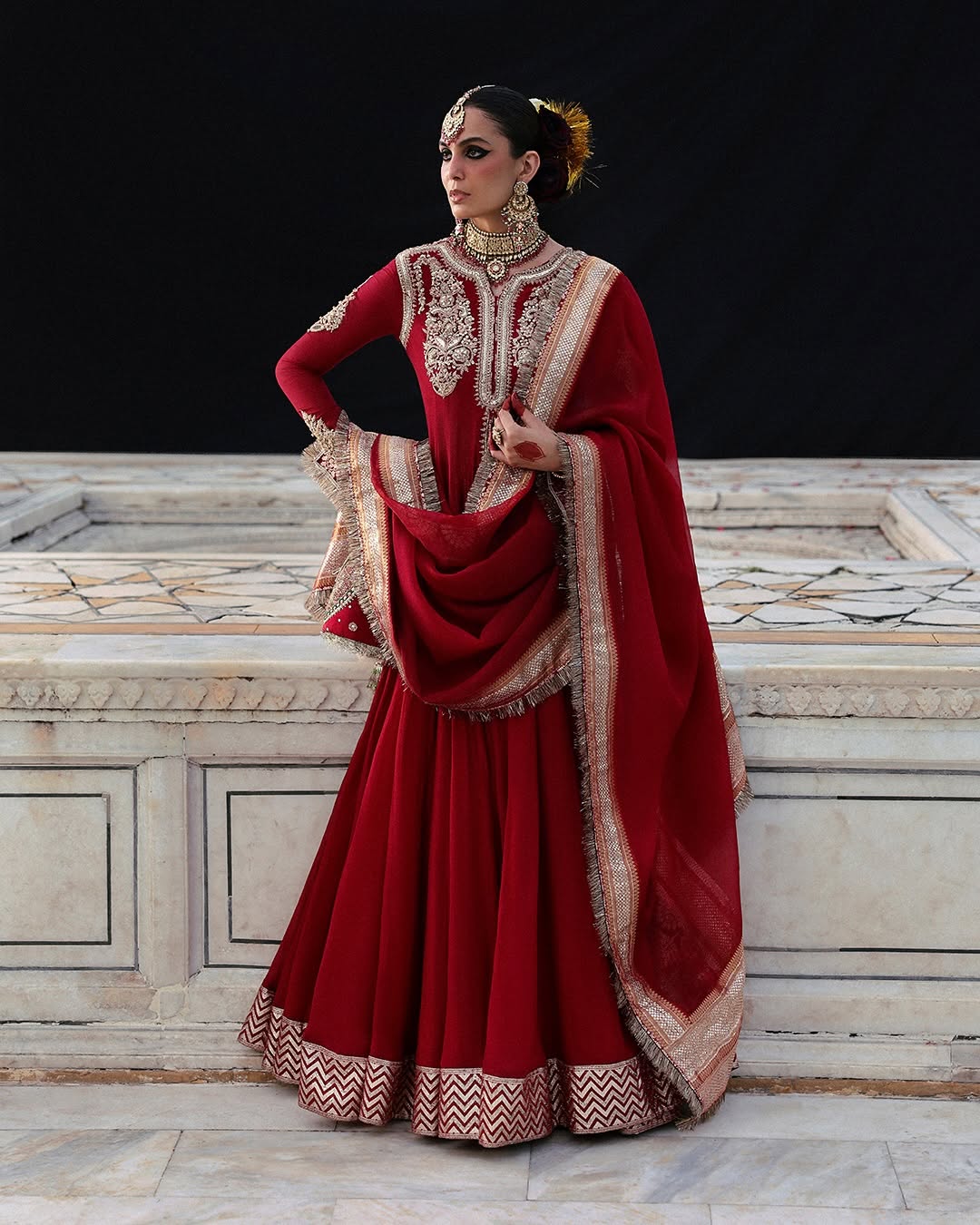 Model wearing Dilrubah by Hussain Rehar in deep red with gold embroidery – regal Pakistani luxury pret outfit in UK.