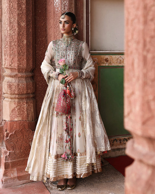 Model wearing Zayrah by Hussain Rehar in ivory and gold with intricate embroidery – regal Pakistani luxury pret outfit in UK.