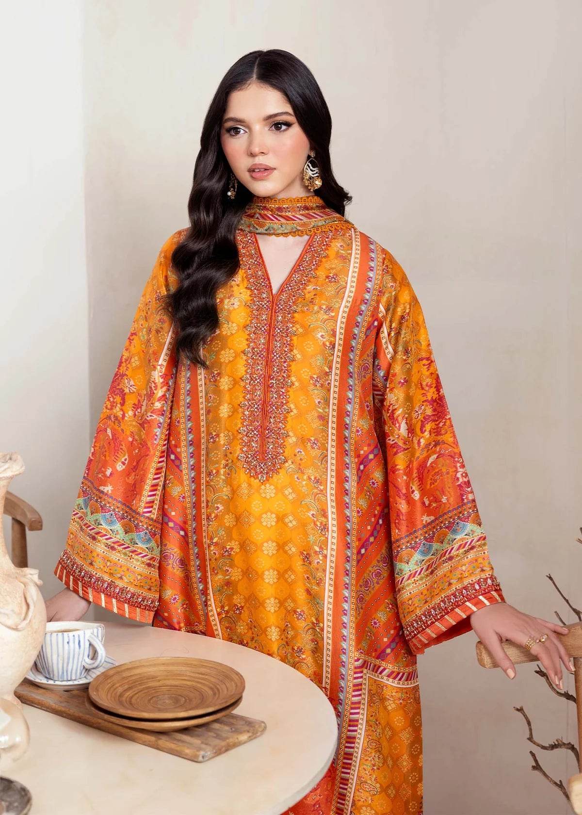Model wearing bright orange printed Maesha from Kanwal Malik Rosalia Silk Eid Collection '25, Pakistani luxury pret online in UK.