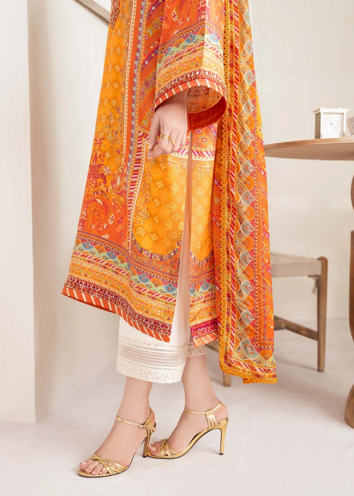 Model wearing bright orange printed Maesha from Kanwal Malik Rosalia Silk Eid Collection '25, Pakistani luxury pret online in UK.