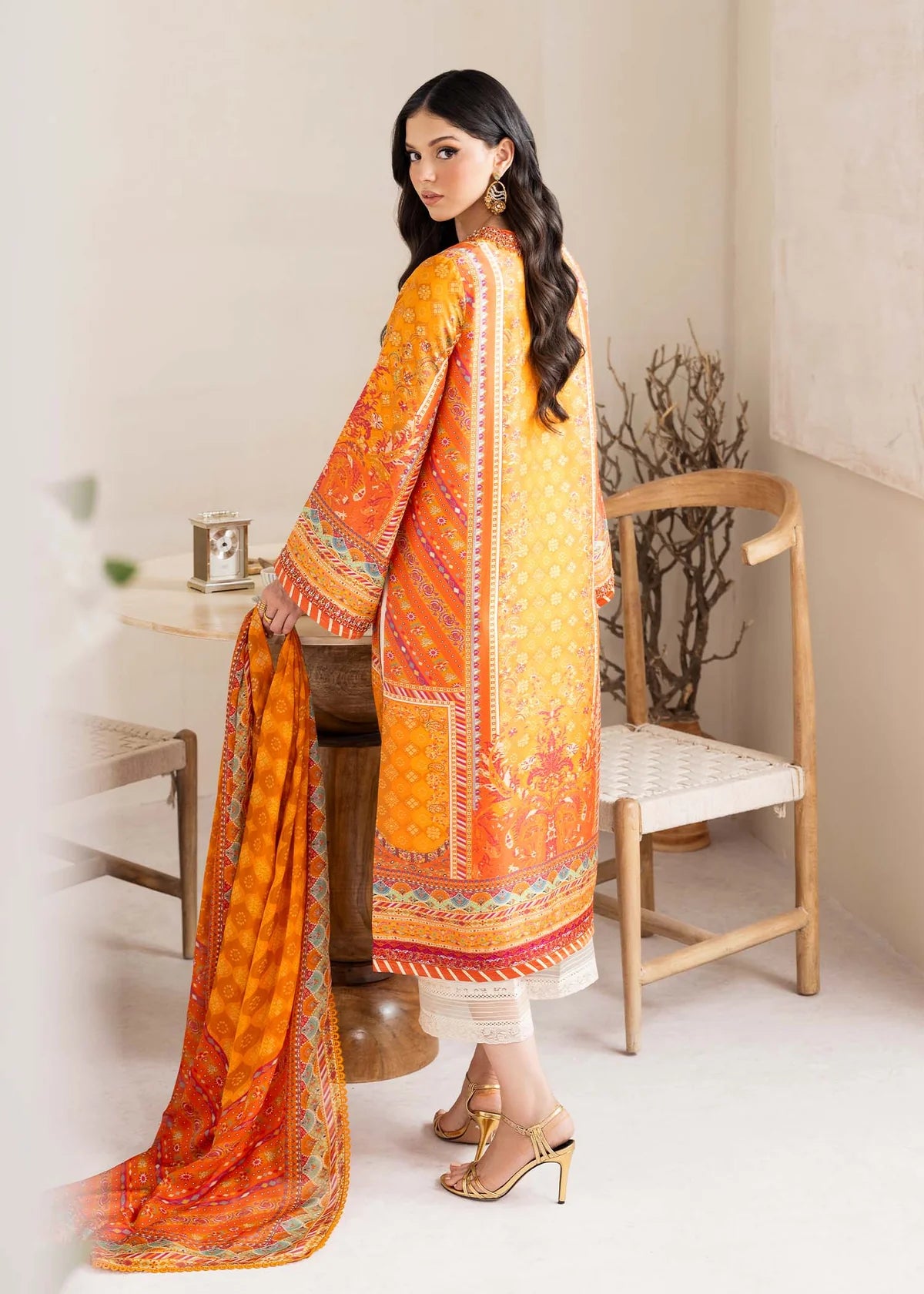 Model wearing bright orange printed Maesha from Kanwal Malik Rosalia Silk Eid Collection '25, Pakistani luxury pret online in UK.