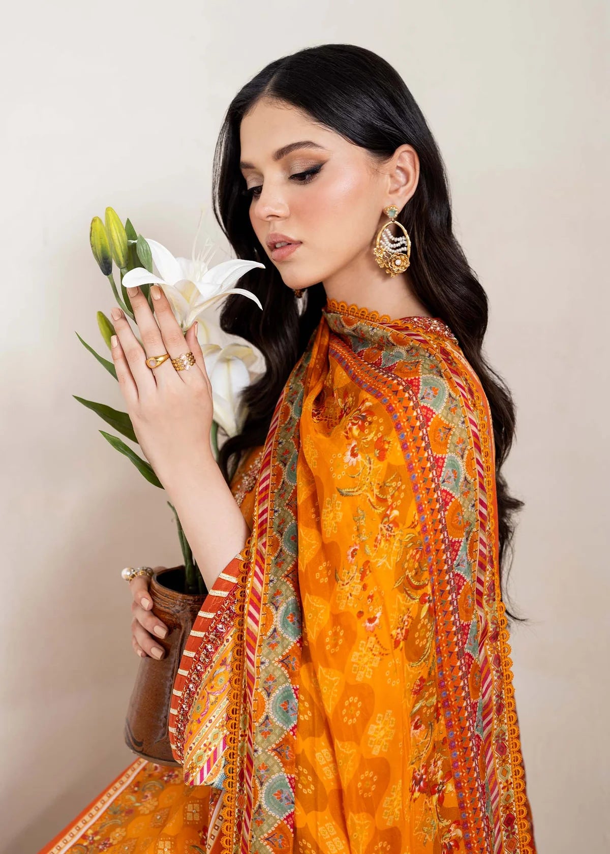 Model wearing bright orange printed Maesha from Kanwal Malik Rosalia Silk Eid Collection '25, Pakistani luxury pret online in UK.