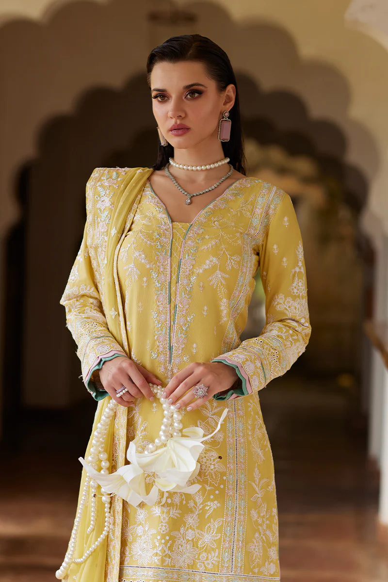 Model wearing Gulaal IRIS mustard yellow luxury lawn dress with delicate white embroidery. Shop Pakistani luxury pret online in the UK.